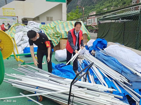 宝兴县司法局党员黄玉刚、林江在拆除群众返家后的帐篷.jpg